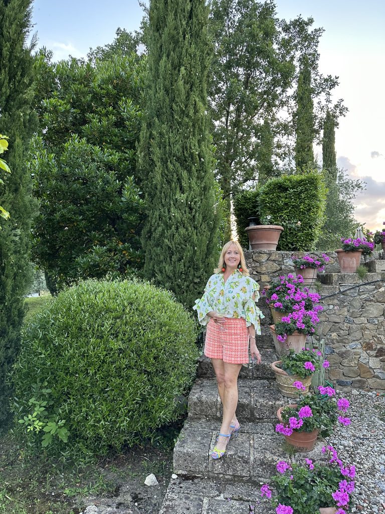 Creative Tonic in bright clothes on steps at Tuscan Villa